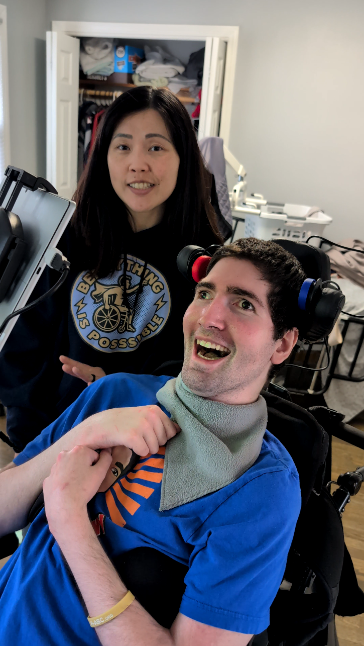 Person using the NARBE Foundation 2-Switch Kit with switches mounted via velcro to wheelchair headrest wings